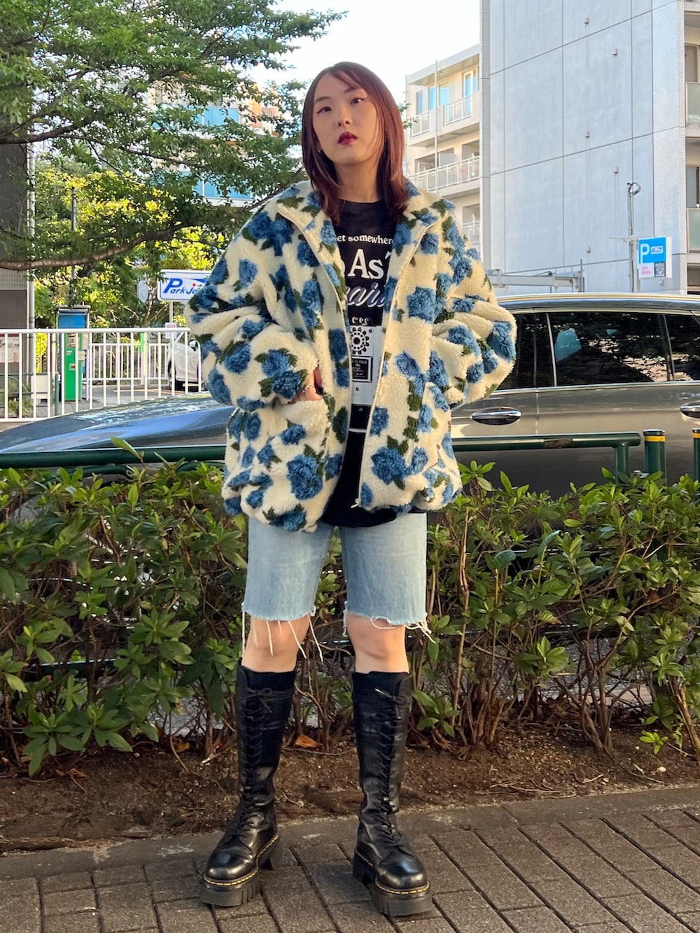 ホワイト系のブルゾン、ブラック系のTシャツ/カットソー、ブラック系のブーツを着用したレディースの秋コーディネートの4枚目の写真