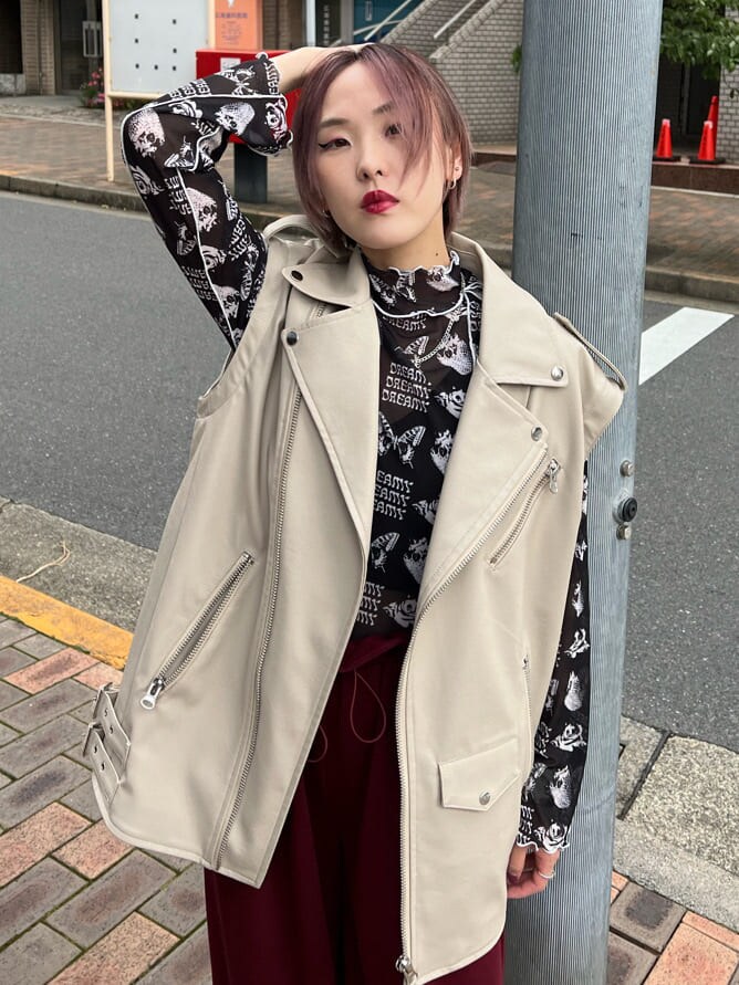 ブラック系のキャミソール、ホワイト系のスニーカー、ホワイト系のライダースジャケットを着用したレディースの秋コーディネートの6枚目の写真