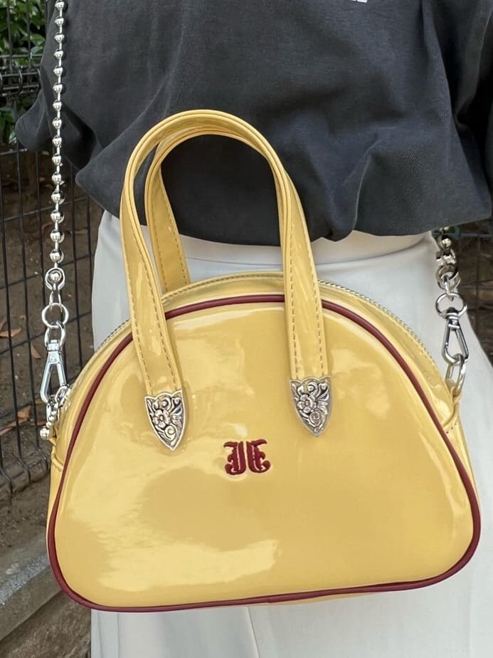 ホワイト系のスカート、イエロー系のボストンバッグ、ブラック系のTシャツ/カットソーを着用したレディースの夏コーディネートの10枚目の写真