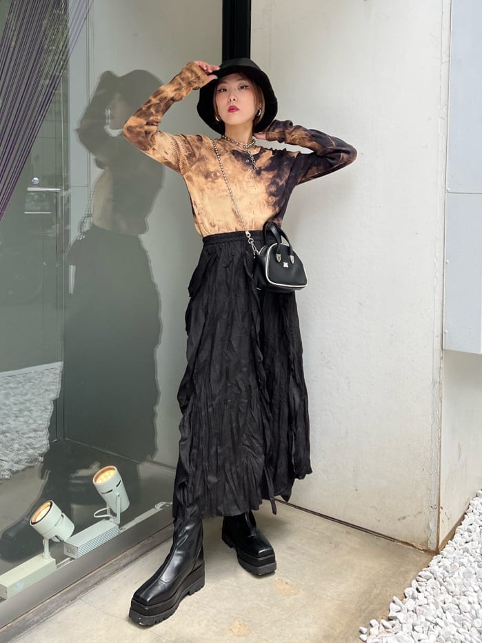 ブラック系のワンピース、ブラック系のTシャツ/カットソー、ブラック系のブーツを着用したレディースの秋コーディネートの2枚目の写真