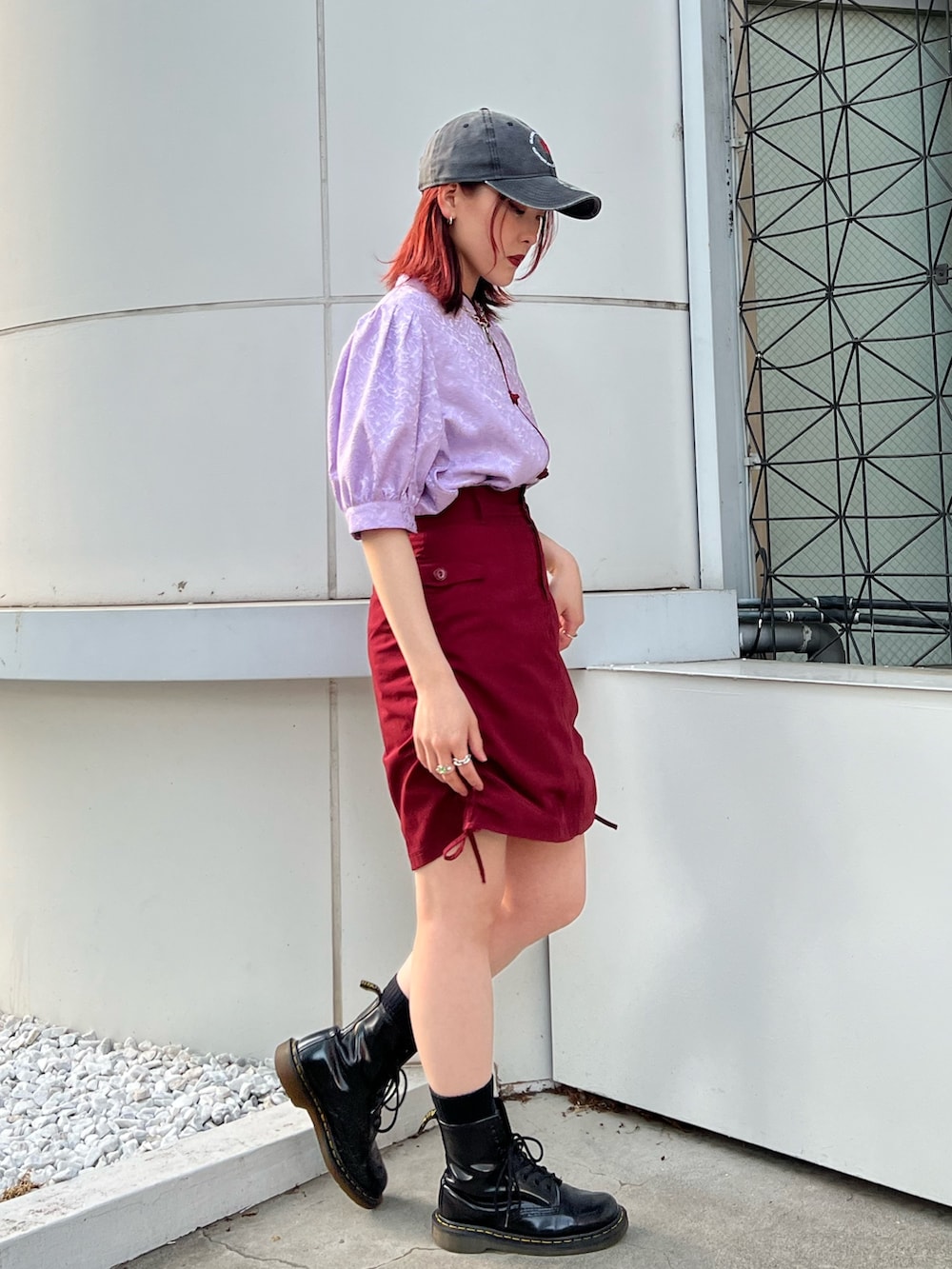 パープル系のシャツ/ブラウス、レッド系のスカート、ブラック系のキャップを着用したレディースの春コーディネートの3枚目の写真