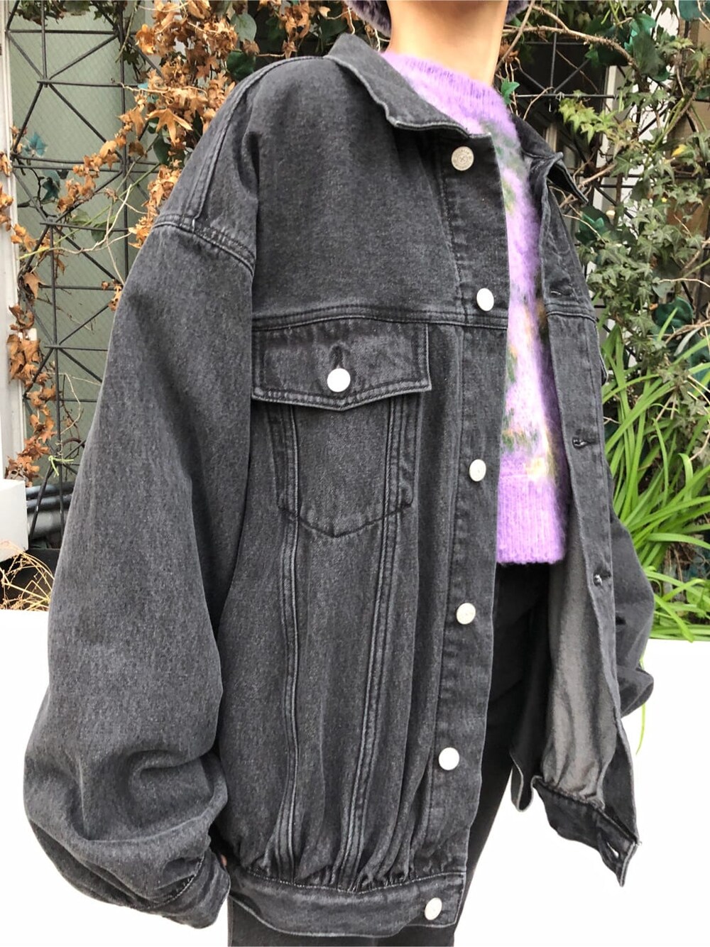 ブラック系のデニムパンツ、ブラック系のデニムジャケット、パープル系のカーディガン/ボレロを着用したレディースの冬コーディネートの9枚目の写真