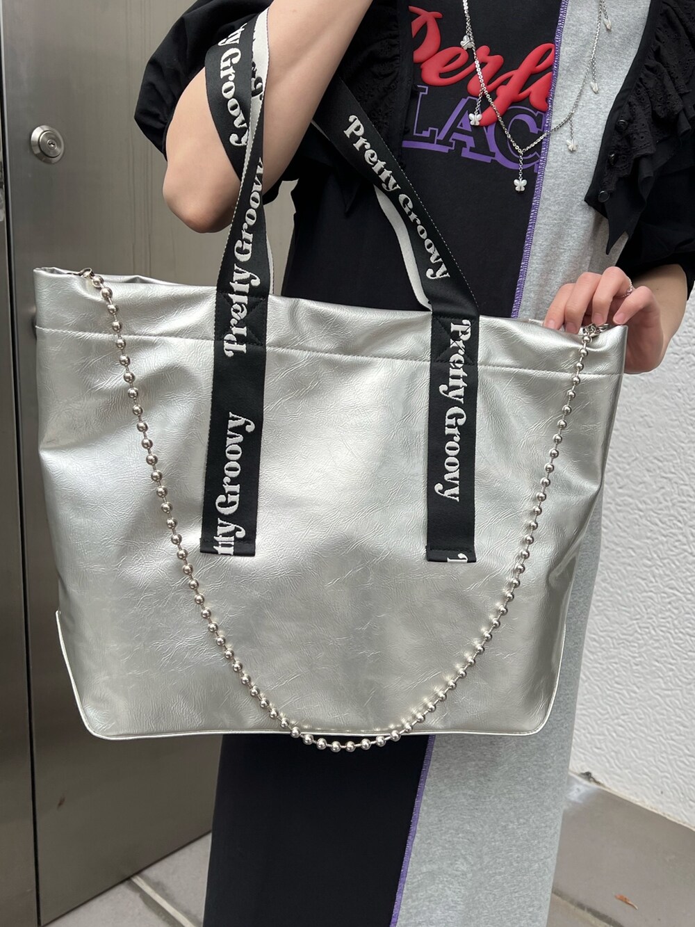 シルバー系のトートバッグ、ブラック系のシャツ/ブラウス、ブラック系のワンピースを着用したレディースの春コーディネートの8枚目の写真