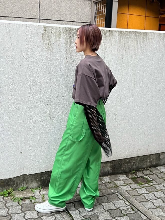 グリーン系のスラックス、ブラック系のTシャツ/カットソー、ブラック系のワンピースを着用したレディースの夏コーディネートの3枚目の写真