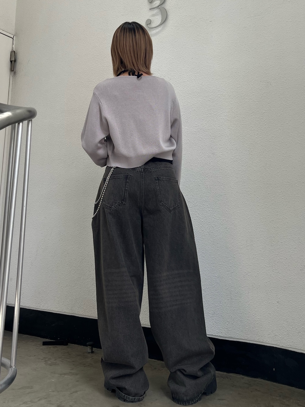 グレー系のニット/セーター、ブラック系のキャミソール、ブラック系のデニムパンツを着用したレディースの春コーディネートの3枚目の写真