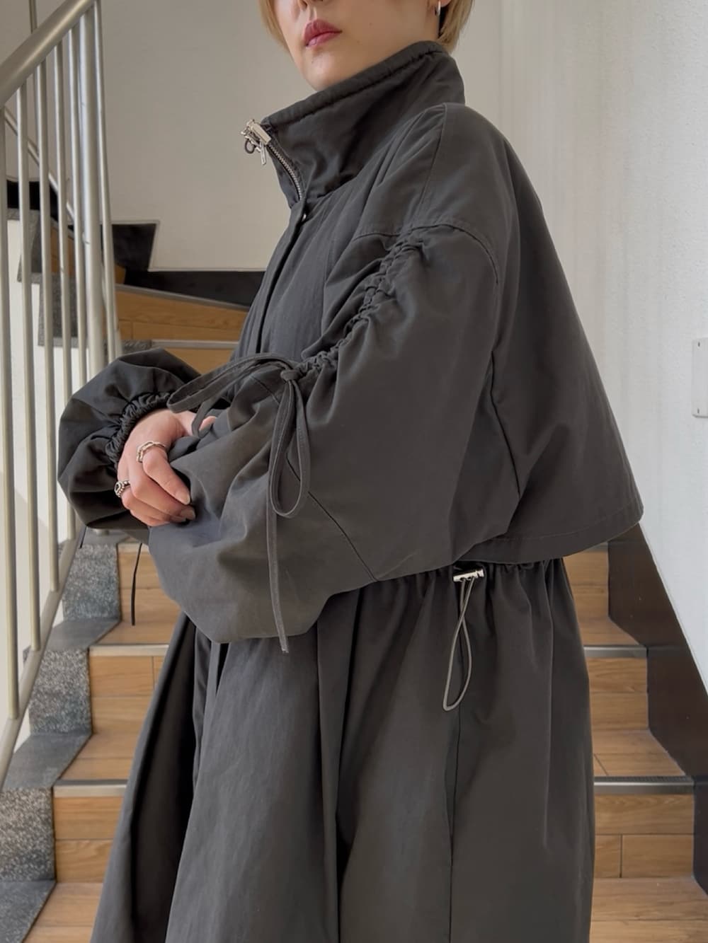 ブラック系のモッズコート、ホワイト系のTシャツ/カットソー、ブラック系のその他パンツを着用したレディースの夏コーディネートの7枚目の写真