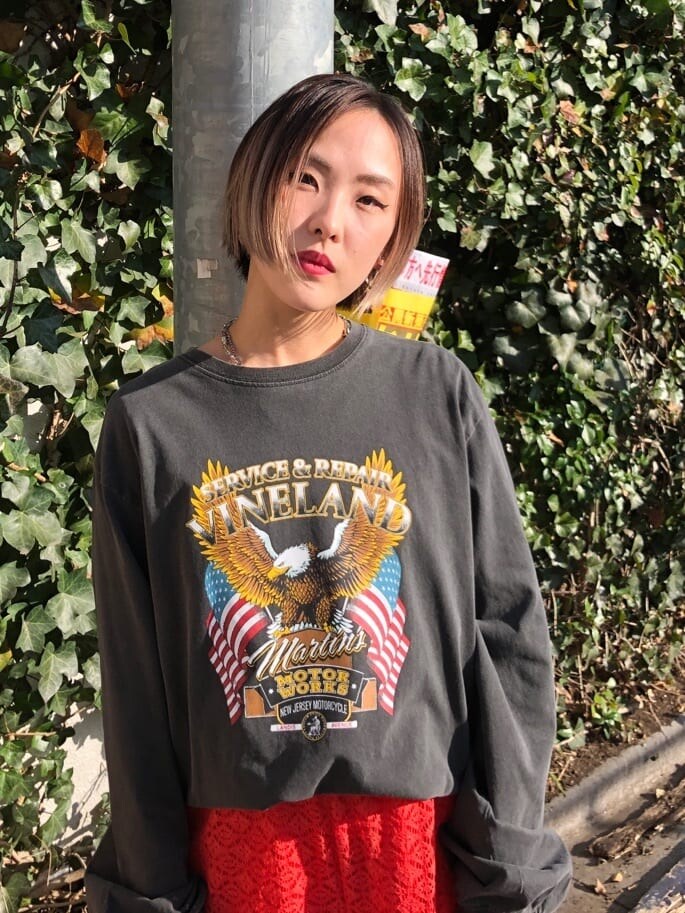 オレンジ系のスラックス、ブラック系のTシャツ/カットソーを着用したレディースの春コーディネートの5枚目の写真