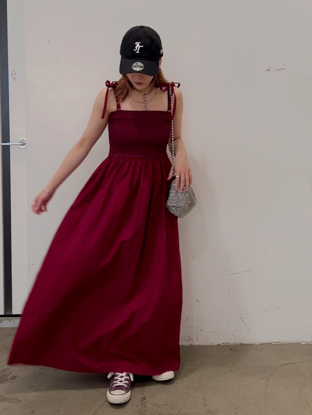 レッド系のワンピース、ホワイト系のショルダーバッグ、パープル系のスニーカーを着用したレディースの夏コーディネートの4枚目の写真