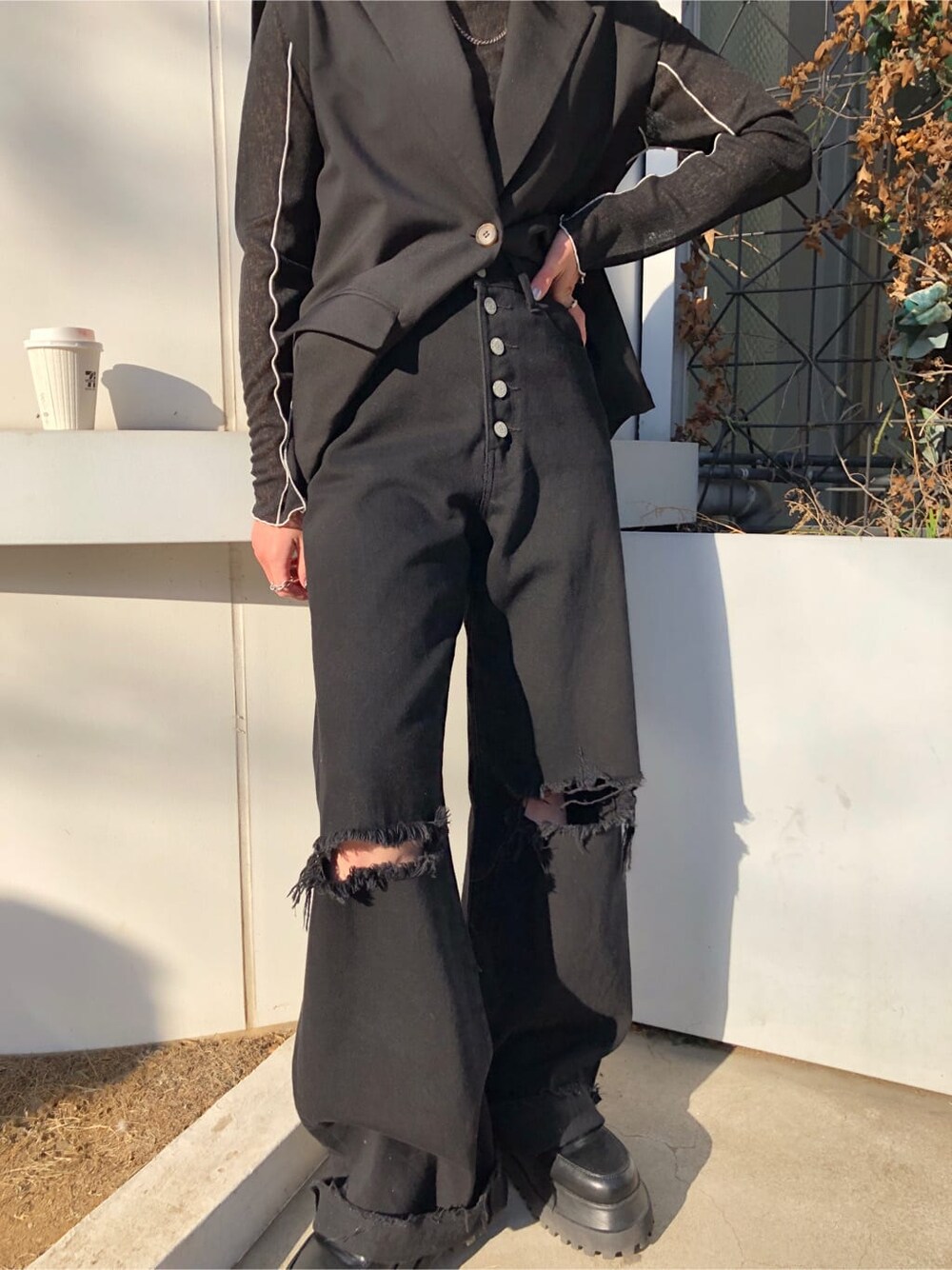 ブラック系のベスト、ブラック系のデニムパンツ、ブラック系のTシャツ/カットソーを着用したレディースの春コーディネートの7枚目の写真