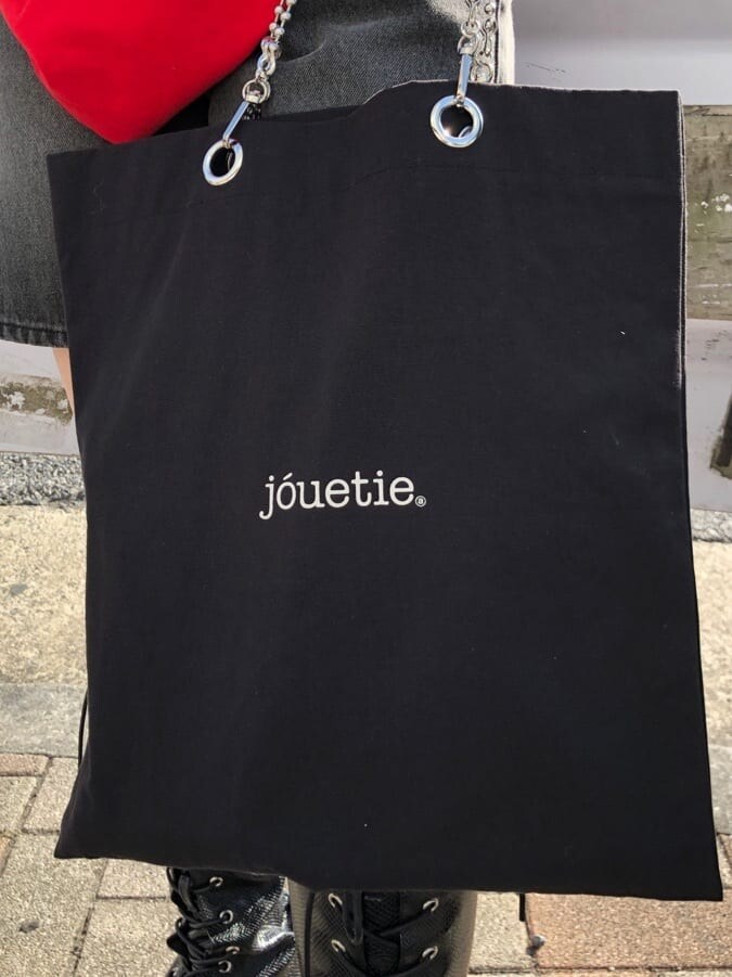 ブラック系のブーツ、ブラック系のトートバッグ、ブラック系のデニムパンツを着用したレディースの春コーディネートの9枚目の写真