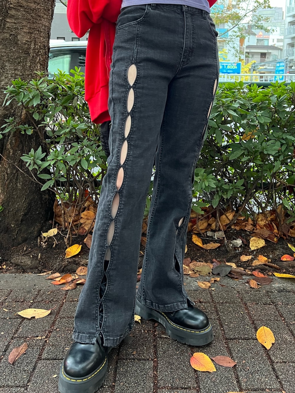 レッド系のパーカー、パープル系のTシャツ/カットソー、ブラック系のデニムパンツを着用したレディースの春コーディネートの8枚目の写真