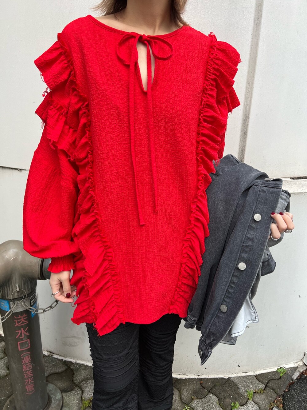 レッド系のシャツ/ブラウス、ブラック系のデニムジャケット、ブラック系のその他パンツを着用したレディースの冬コーディネートの6枚目の写真