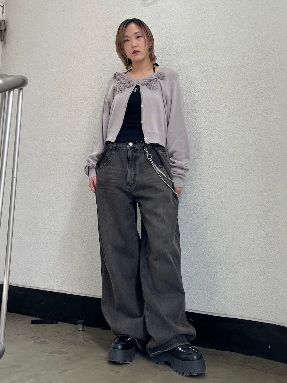 グレー系のニット/セーター、ブラック系のキャミソール、ブラック系のデニムパンツを着用したレディースの春コーディネートの5枚目の写真