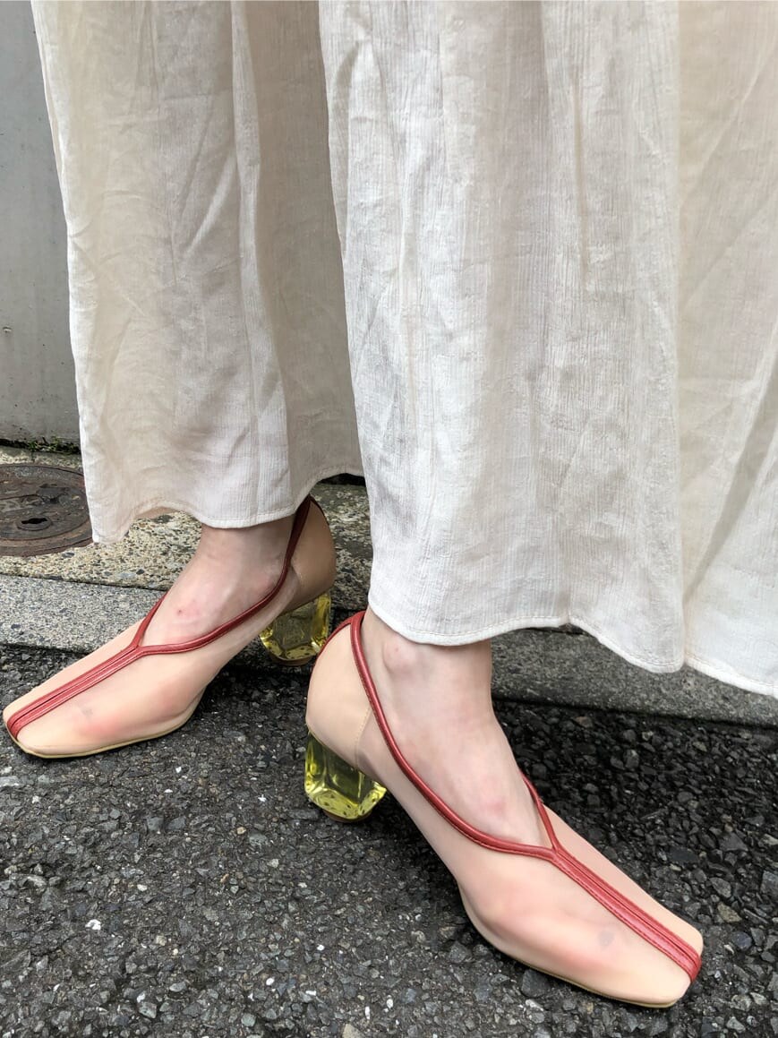 ホワイト系のワンピース、ホワイト系のパンプス、オレンジ系のハンドバッグを着用したレディースの夏コーディネートの9枚目の写真