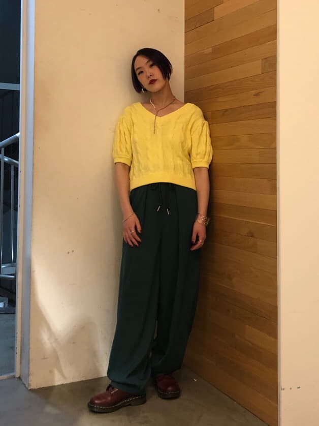 グリーン系のスラックス、イエロー系のニット/セーター、シルバー系のネックレスを着用したレディースの冬コーディネートの4枚目の写真