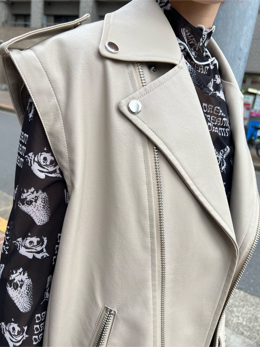 ブラック系のキャミソール、ホワイト系のスニーカー、ホワイト系のライダースジャケットを着用したレディースの秋コーディネートの7枚目の写真