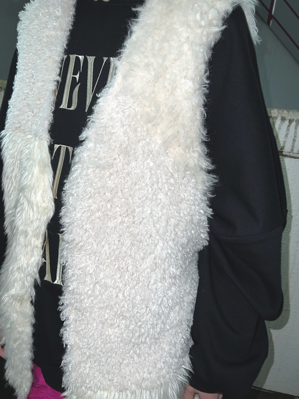 ブラック系のスウェット、ホワイト系のベスト、ピンク系のスカートを着用したレディースの冬コーディネートの8枚目の写真