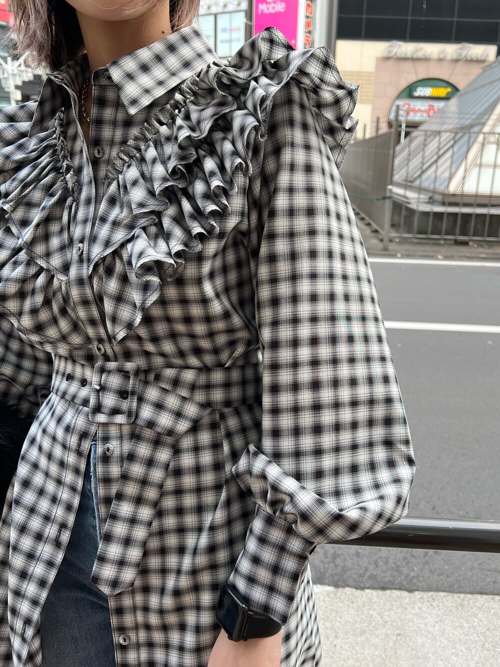 ブラック系のワンピース、ブラック系のベスト、ブルー系のデニムパンツを着用したレディースの冬コーディネートの9枚目の写真