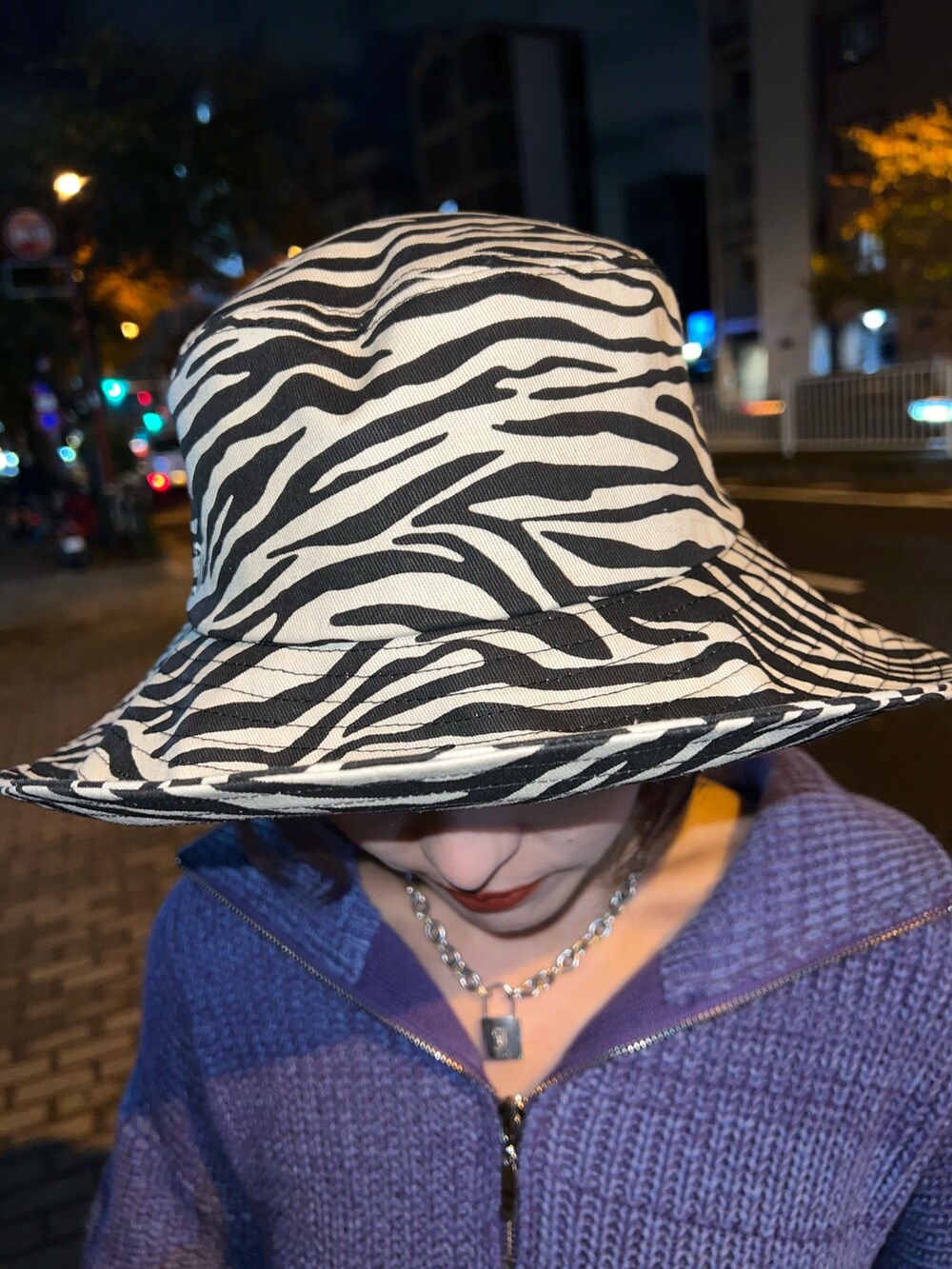 パープル系のニット/セーター、ブラック系のデニムパンツ、ホワイト系のハットを着用したレディースの冬コーディネートの9枚目の写真