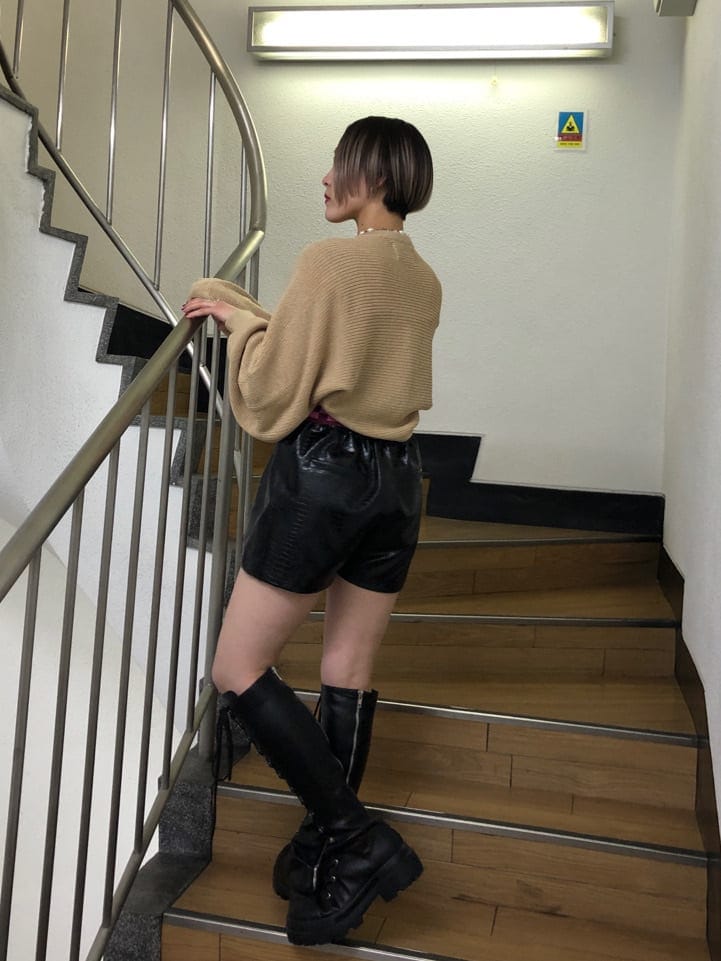 ベージュ系のトレンチコート、ブラック系のその他パンツ、ブラック系のブーツを着用したレディースの春コーディネートの5枚目の写真