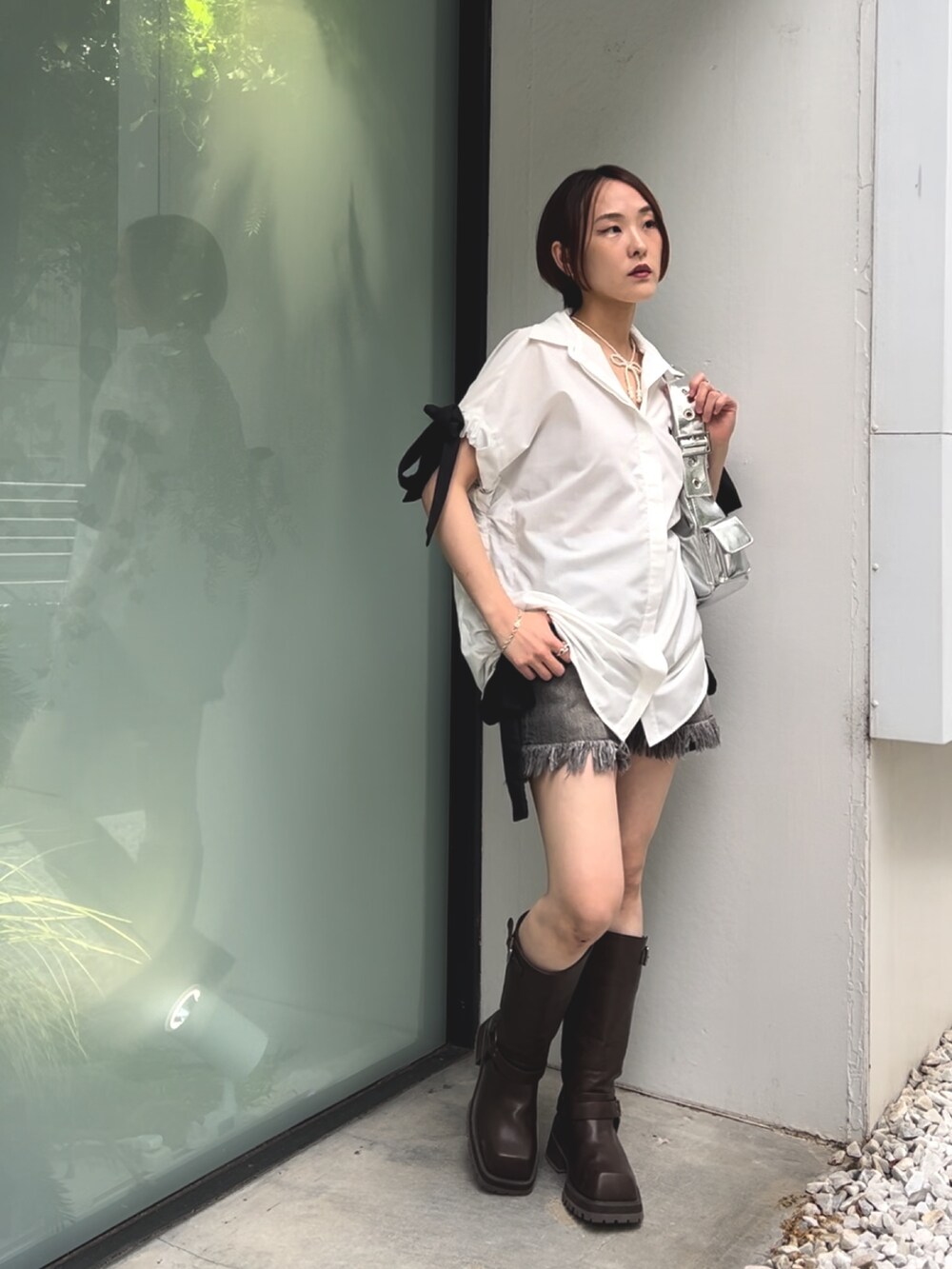 ホワイト系のシャツ/ブラウス、シルバー系のハンドバッグ、ブラック系のデニムパンツを着用したレディースの夏コーディネートの3枚目の写真