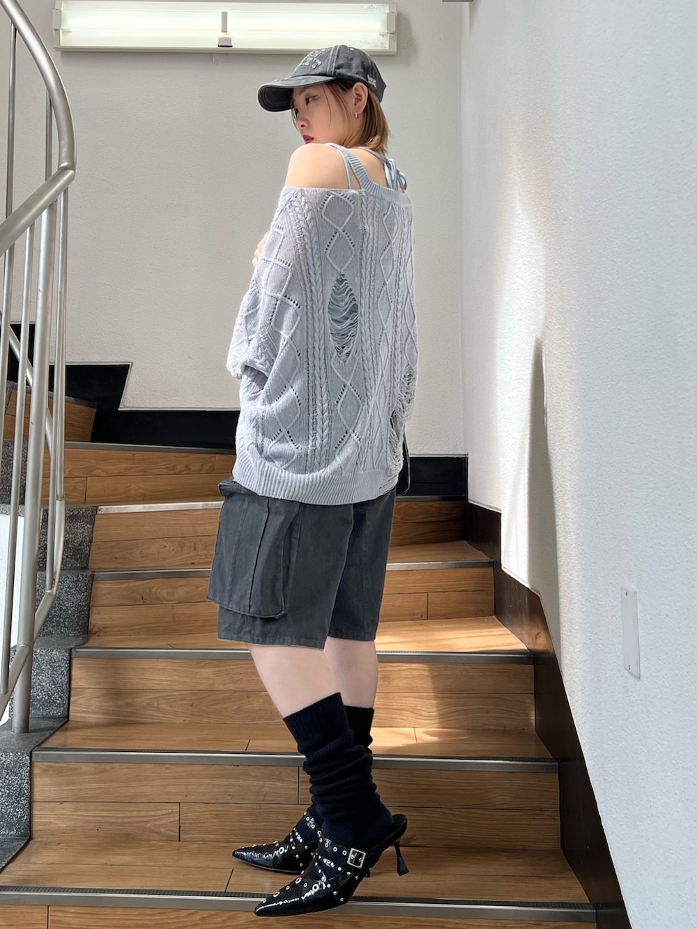 ブラック系のパンプス、ブラック系のカーゴパンツ、ブルー系のキャミソールを着用したレディースの春コーディネートの3枚目の写真