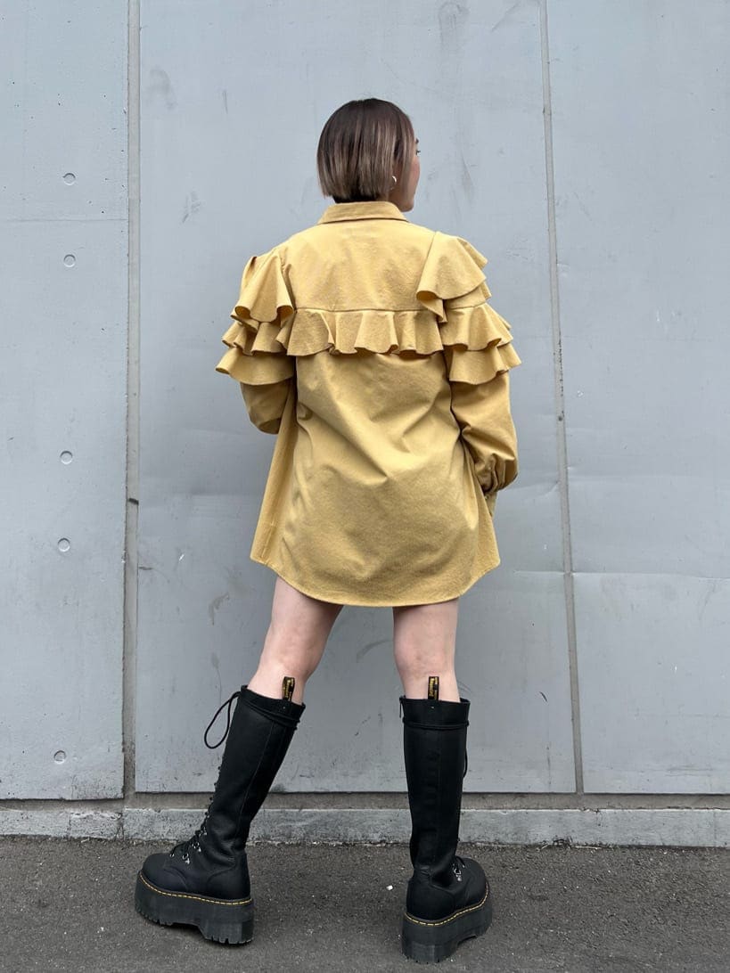 ブルー系のデニムパンツ、ブラック系のブーツ、イエロー系のシャツ/ブラウスを着用したレディースの春コーディネートの4枚目の写真