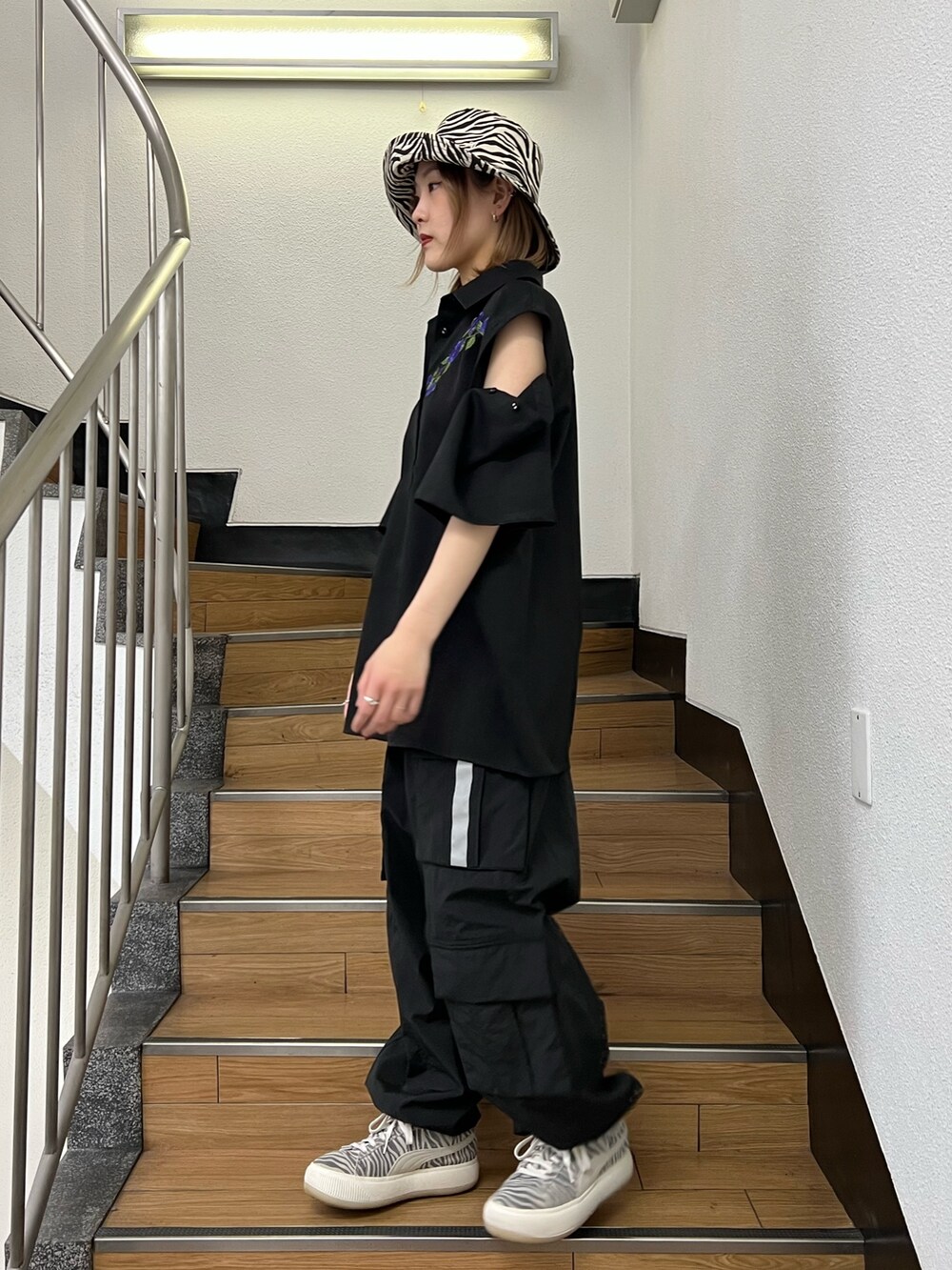 ブラック系のカーゴパンツ、ブラック系のシャツ/ブラウス、ホワイト系のハットを着用したレディースの春コーディネートの3枚目の写真