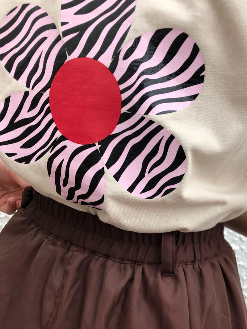 ブラウン系のスカート、ホワイト系のTシャツ/カットソー、ゴールド系のチョーカーを着用したレディースの夏コーディネートの5枚目の写真