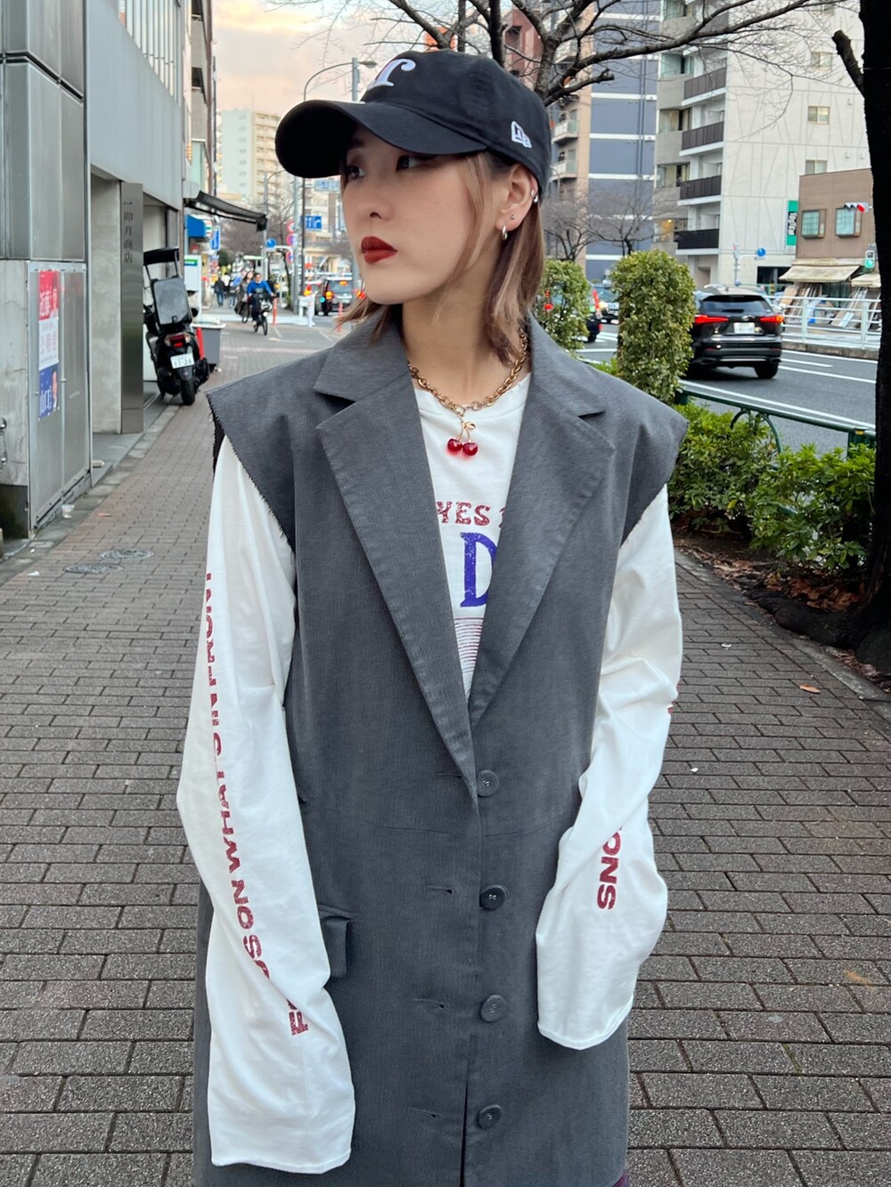 ブルー系のスカート、ホワイト系のTシャツ/カットソー、グレー系のベストを着用したレディースの春コーディネートの5枚目の写真