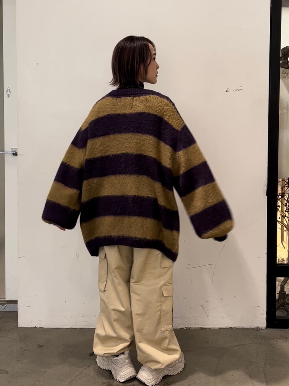 パープル系のカーディガン/ボレロ、ホワイト系のカーゴパンツ、ブラック系のスウェットを着用したレディースの秋コーディネートの4枚目の写真