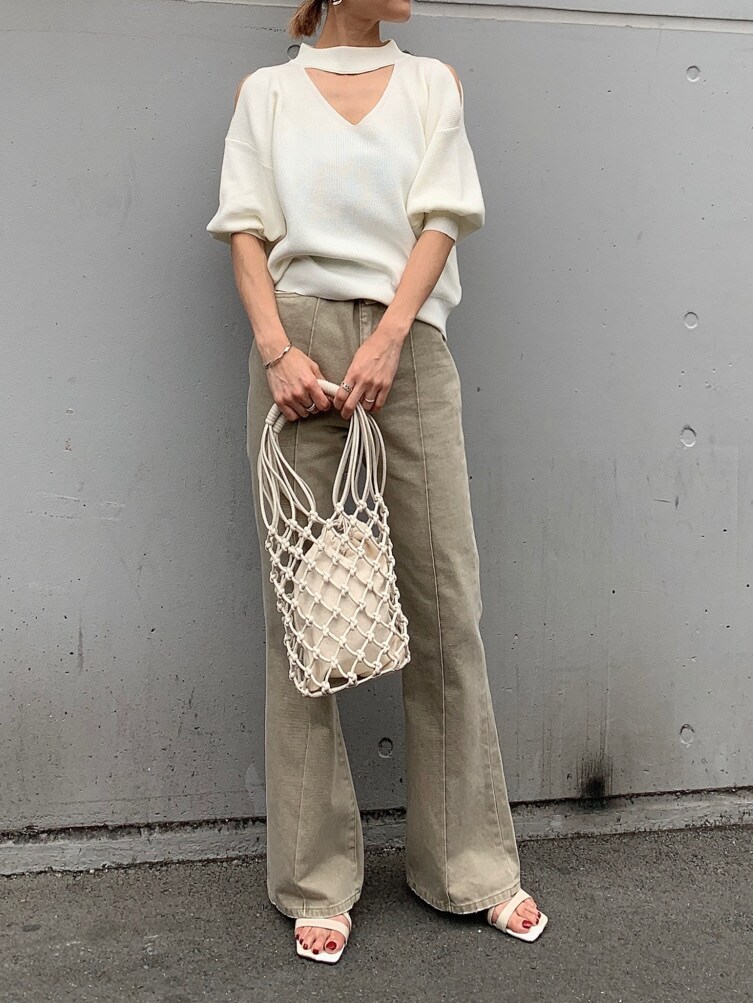 ベージュ系のその他パンツ、ホワイト系のニット/セーター、ホワイト系のハンドバッグを着用したレディースの春コーディネートの4枚目の写真