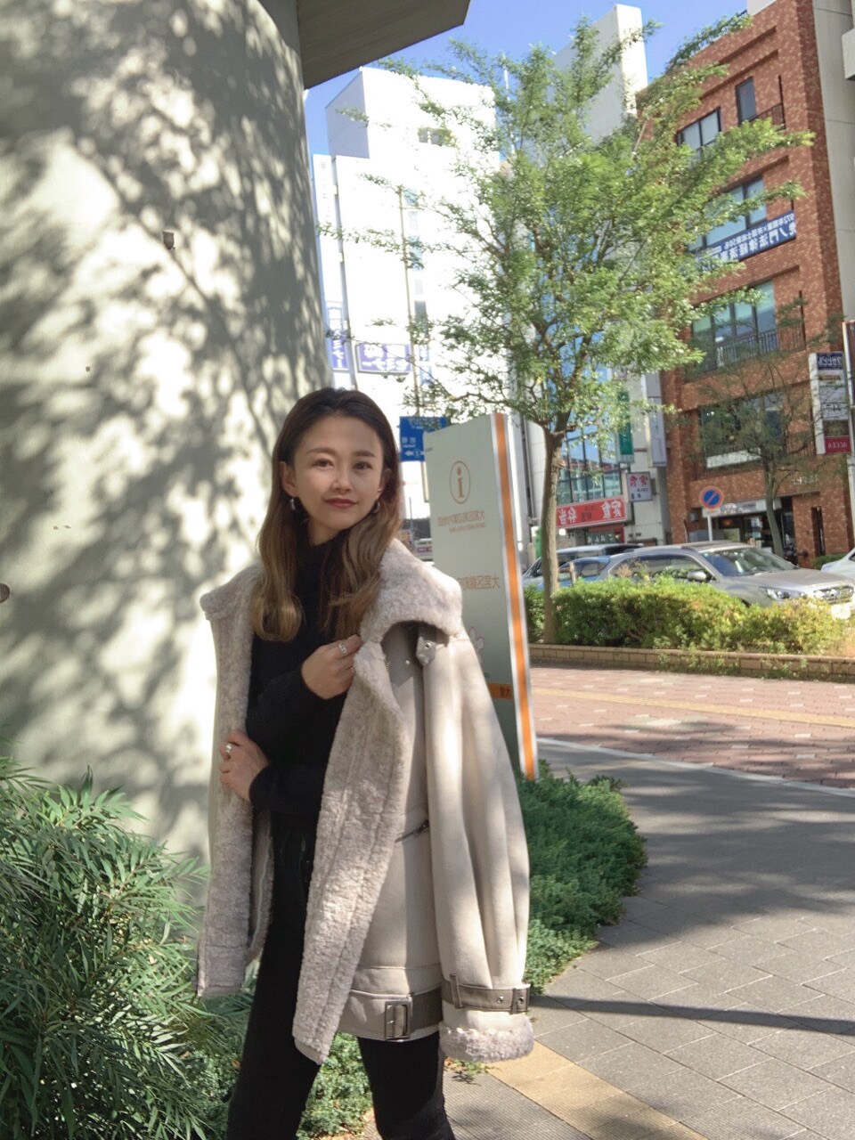 ブラック系のその他パンツ、ブラック系のニット/セーター、グレー系のムートンコートを着用したレディースの秋コーディネートの2枚目の写真