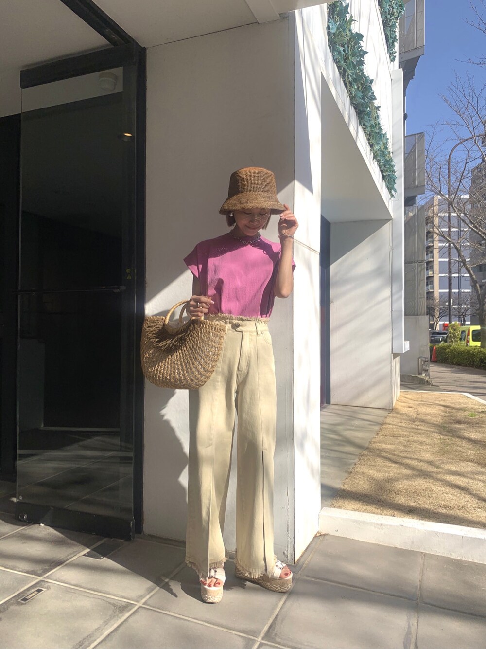 イエロー系のその他パンツ、ベージュ系のかごバッグ、ホワイト系のサンダルを着用したレディースの春コーディネートの4枚目の写真