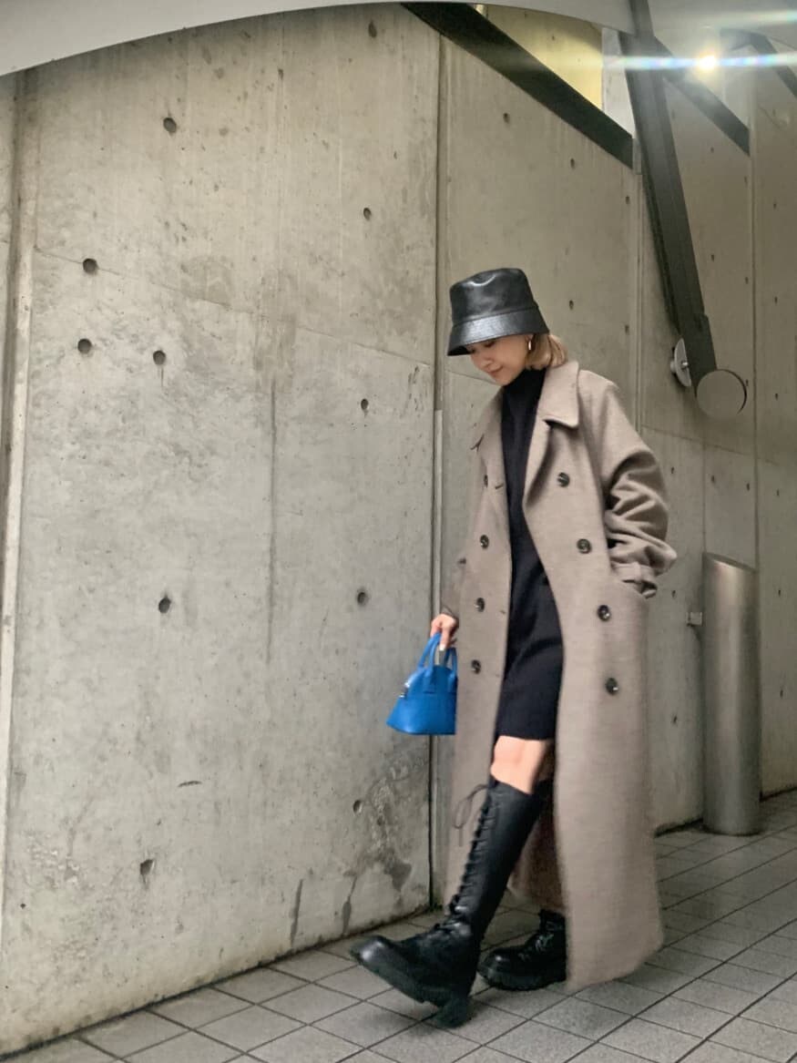 ブラック系のワンピース、ベージュ系のチェスターコート、ブラック系のブーツを着用したレディースの冬コーディネートの3枚目の写真