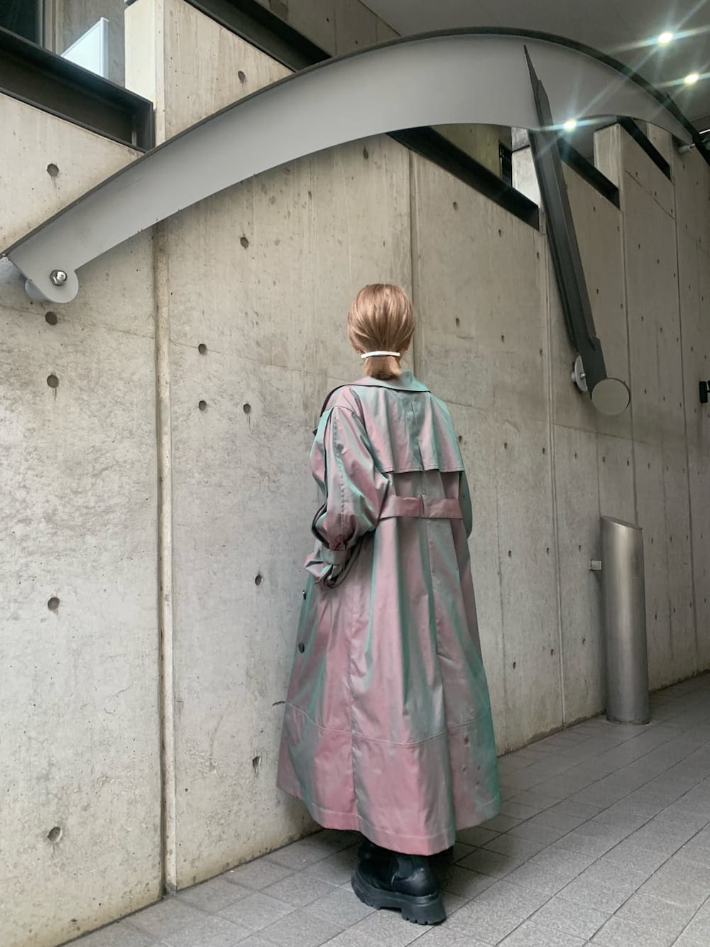 ベージュ系のトレンチコート、ブルー系のワンピース、ブラック系のブーツを着用したレディースの冬コーディネートの5枚目の写真