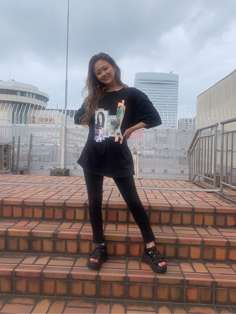 ブラック系のデニムパンツ、ブラック系のTシャツ/カットソー、ブラック系のサンダルを着用したレディースの夏コーディネートの2枚目の写真