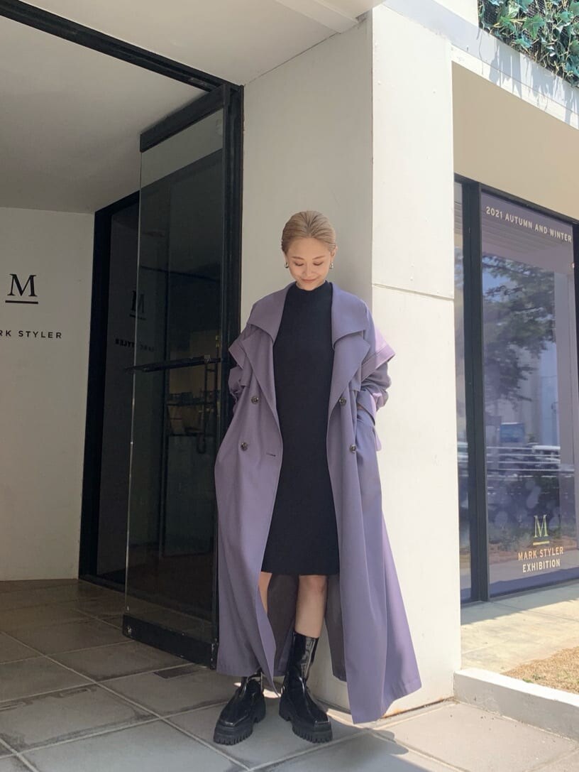 パープル系のトレンチコート、ブラック系のブーツを着用したレディースの夏コーディネートの2枚目の写真