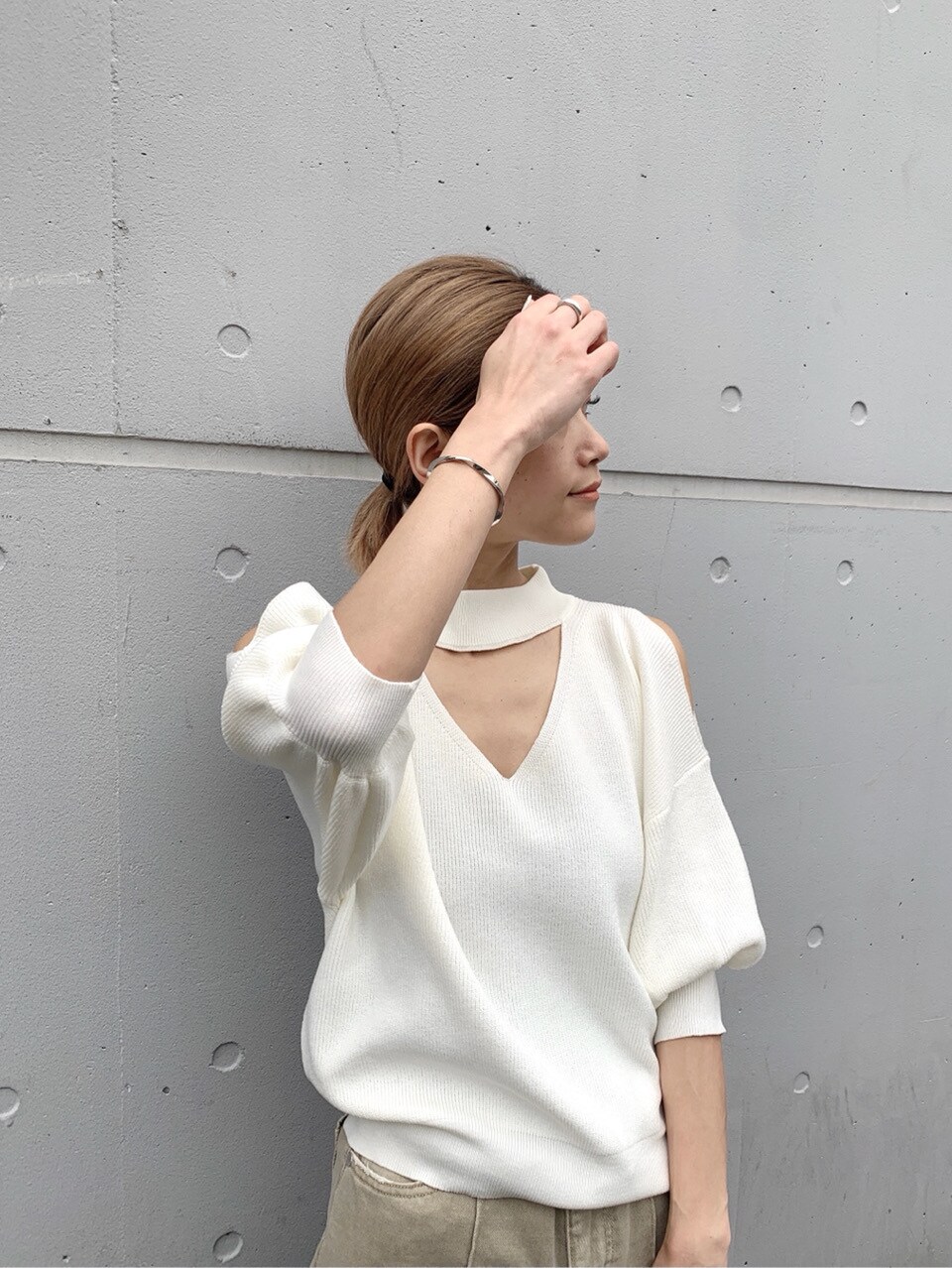 ベージュ系のその他パンツ、ホワイト系のニット/セーター、ホワイト系のハンドバッグを着用したレディースの春コーディネートの2枚目の写真