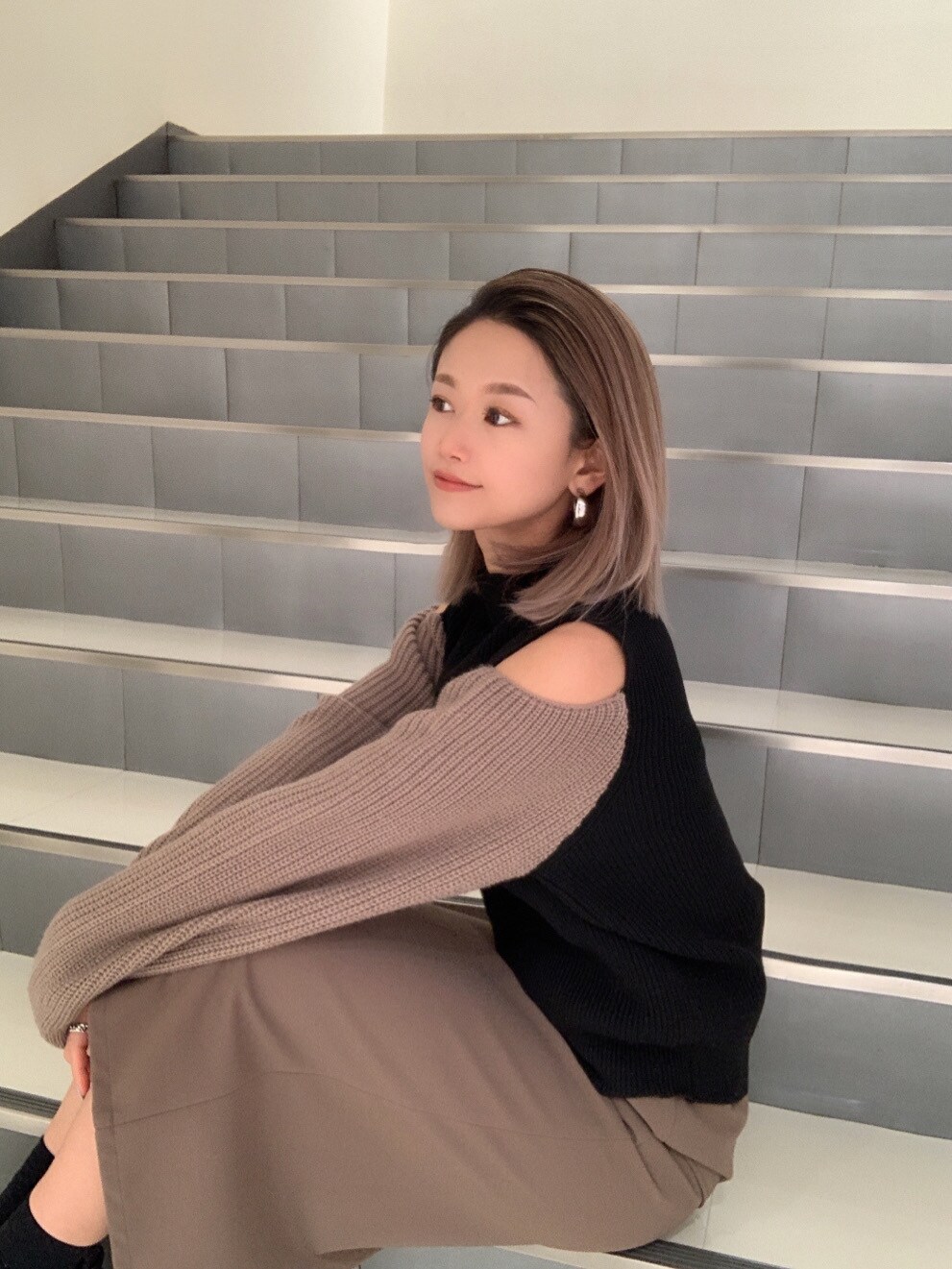 ベージュ系のスカートを着用したレディースの冬コーディネートの2枚目の写真