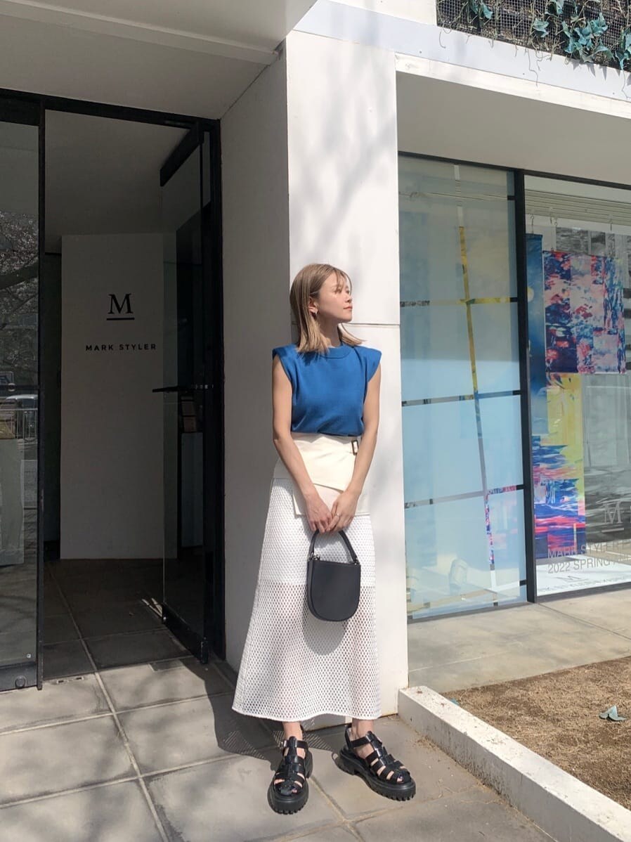 ホワイト系のスカート、ブラック系のサンダル、ブルー系のタンクトップを着用したレディースの春コーディネートの2枚目の写真