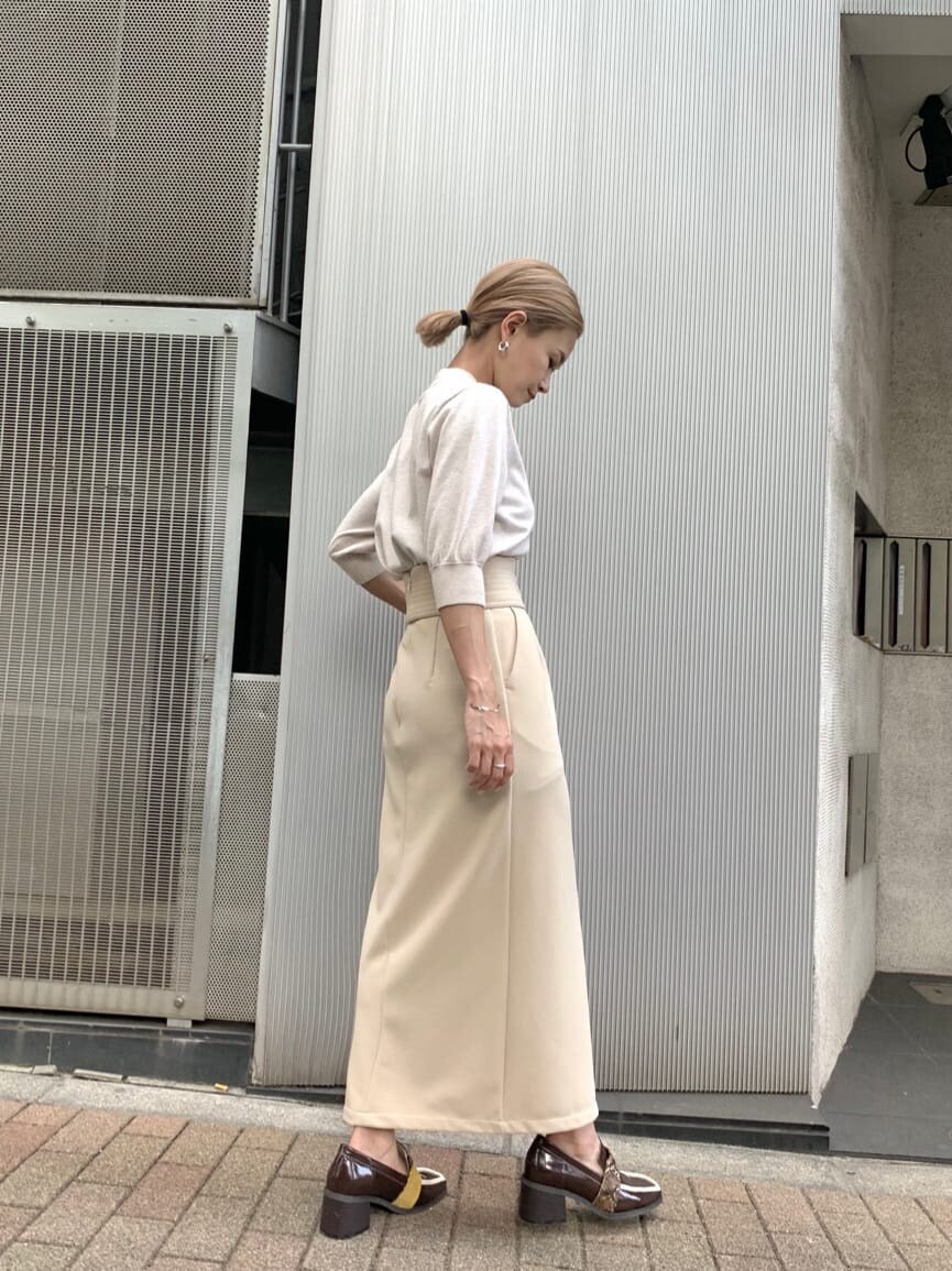 ホワイト系のニット/セーター、ホワイト系のスカート、ブラウン系のローファーを着用したレディースの夏コーディネートの2枚目の写真