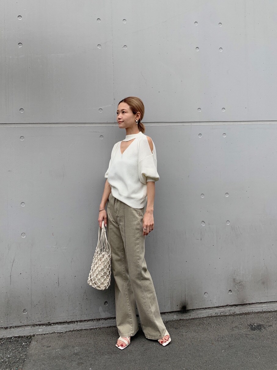 ベージュ系のその他パンツ、ホワイト系のニット/セーター、ホワイト系のハンドバッグを着用したレディースの春コーディネートの3枚目の写真