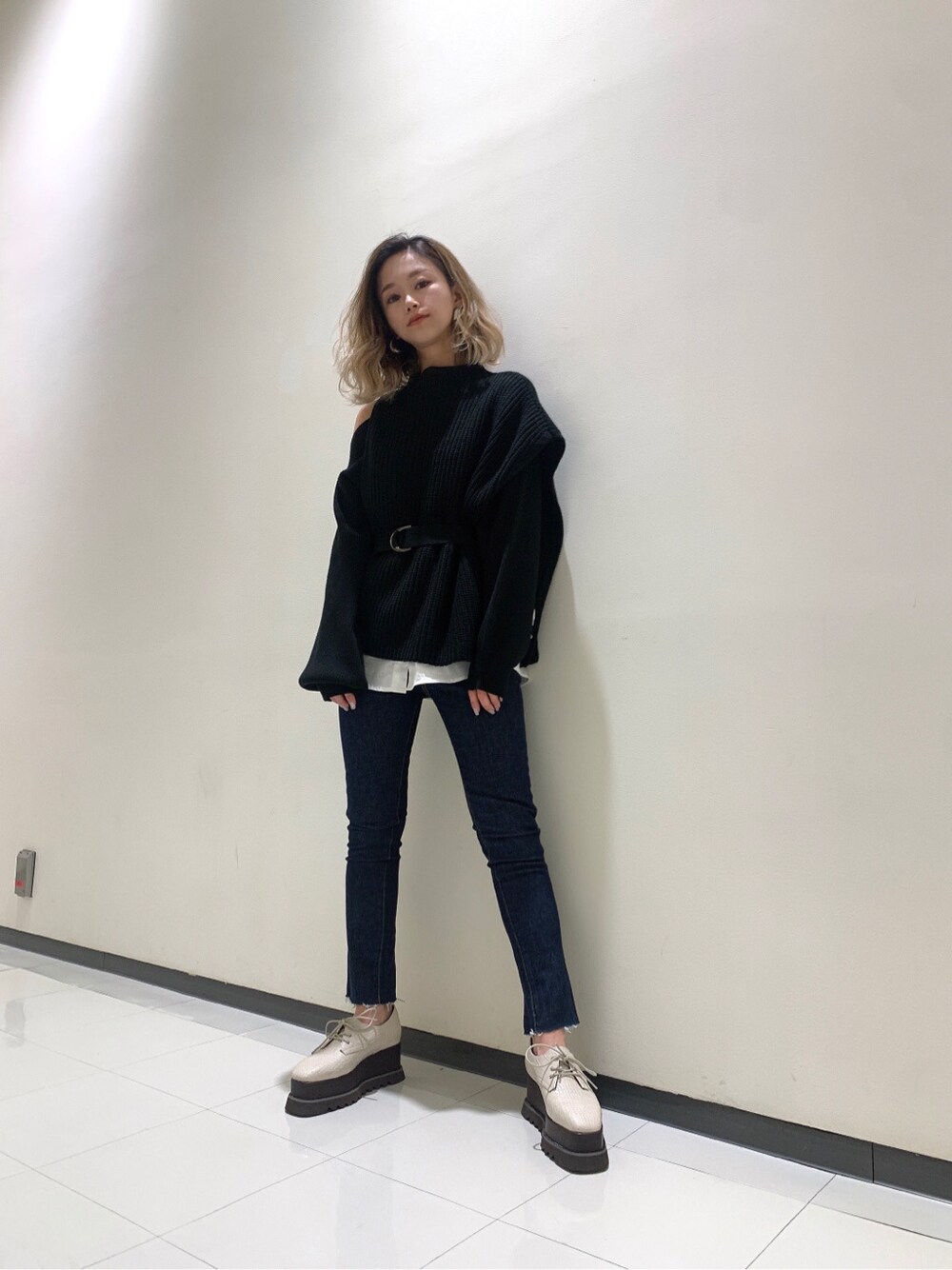 ホワイト系のローファー、ブルー系のデニムパンツを着用したレディースの冬コーディネートの2枚目の写真