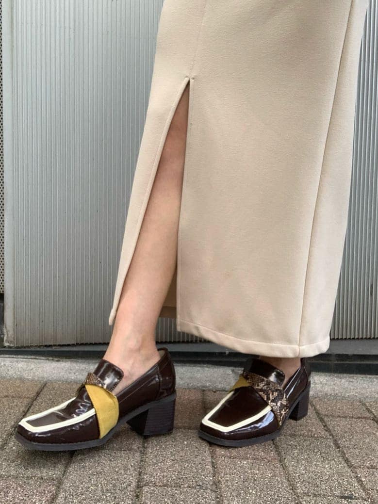 ホワイト系のニット/セーター、ホワイト系のスカート、ブラウン系のローファーを着用したレディースの夏コーディネートの3枚目の写真