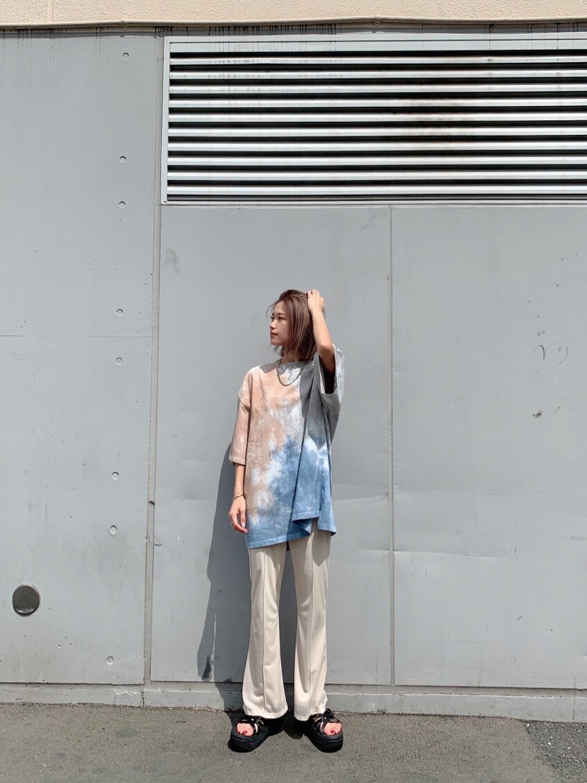 ホワイト系のスラックス、ブラック系のサンダル、その他のTシャツ/カットソーを着用したレディースの春コーディネートの2枚目の写真