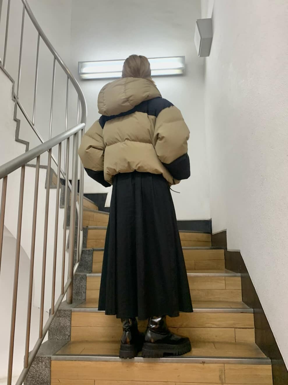 グリーン系のダウンジャケット/コート、ベージュ系のダウンジャケット/コート、ブラック系のブーツを着用したレディースの夏コーディネートの5枚目の写真