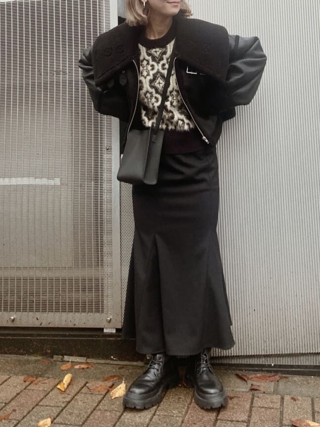 ブラック系のブルゾン、ブラック系のニット/セーター、ブラック系のスカートを着用したレディースの秋コーディネートの2枚目の写真