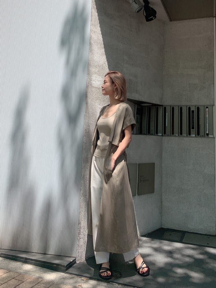 ブラック系のキャミソール、ホワイト系のスラックス、ブラック系のサンダルを着用したレディースの夏コーディネートの2枚目の写真