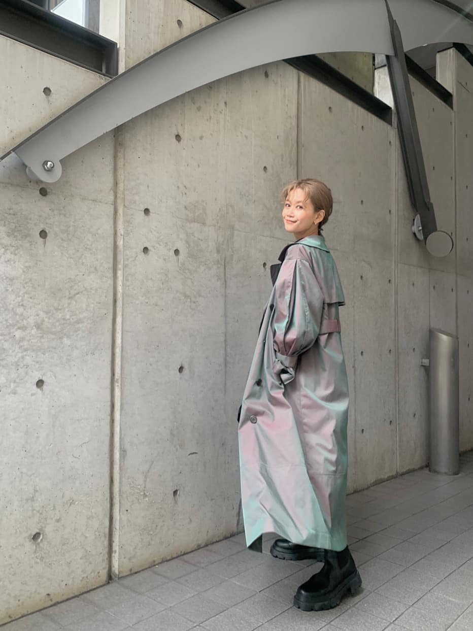 ベージュ系のトレンチコート、ブルー系のワンピース、ブラック系のブーツを着用したレディースの冬コーディネートの4枚目の写真